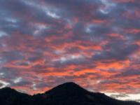 Rotglühende abendliche Wolkenhäufchen über dem Aschauer Berg